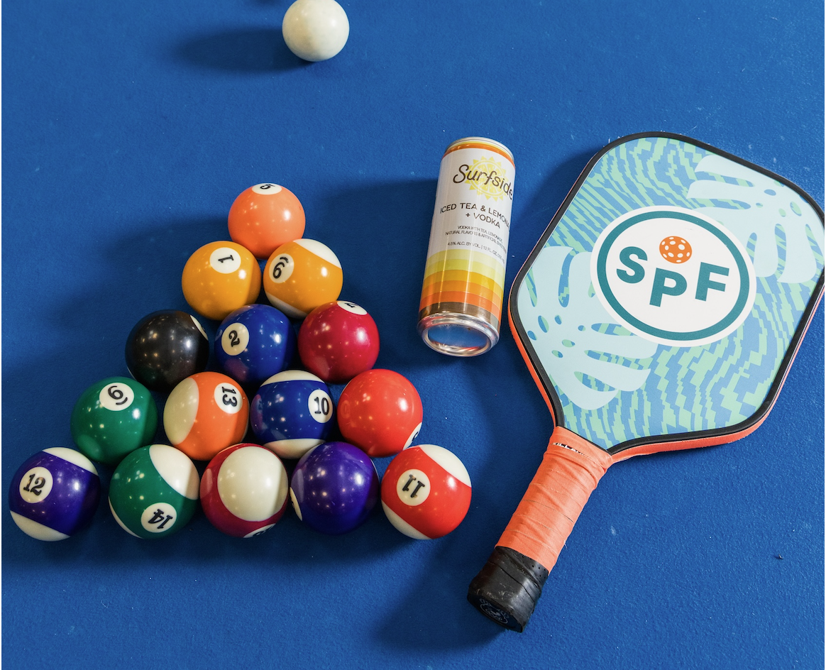SPF pickleball paddle beside a rack of pool balls